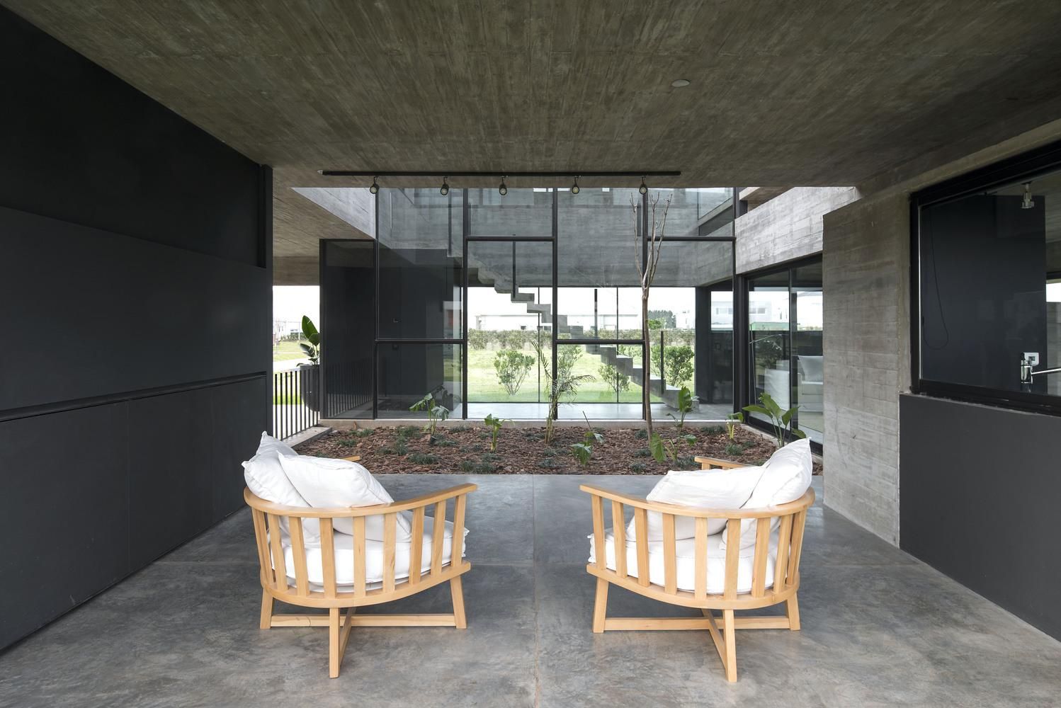 Величие бетона и клумба посреди комнаты: интересный проект частного дома из Аргентины